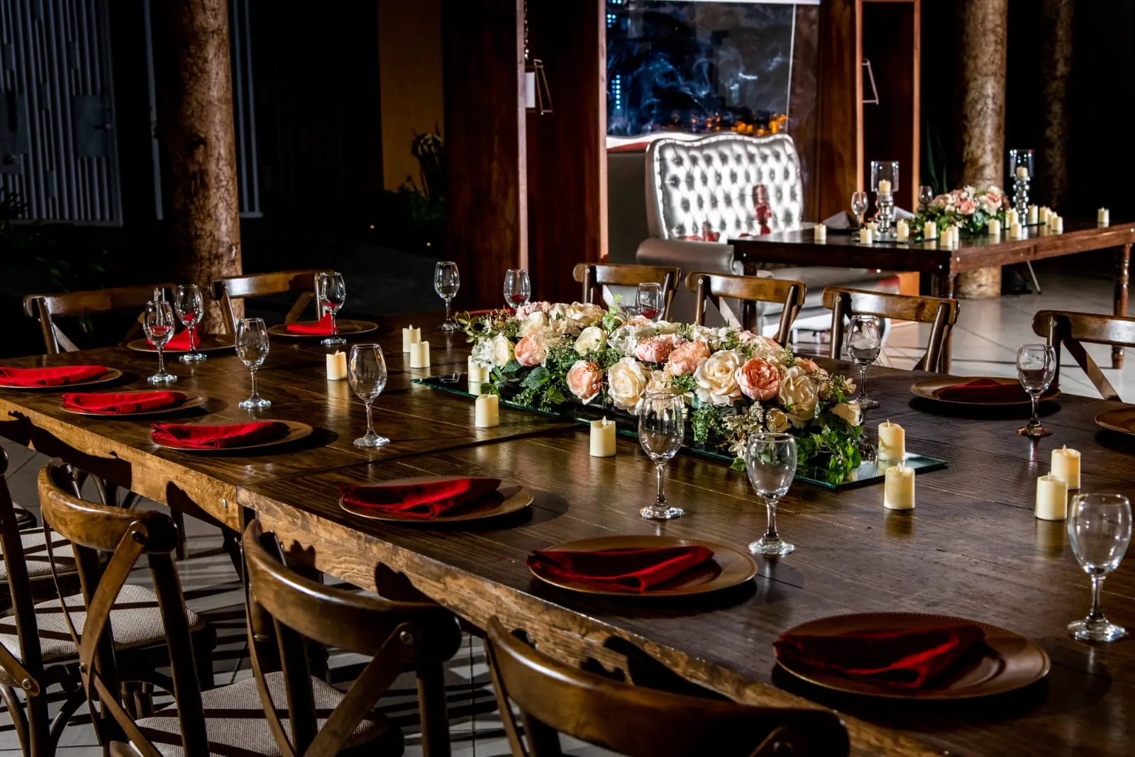 Salón de Bonanza de noche con mesas de madera, servilletas rojas y el sillón de los festejados al fondo